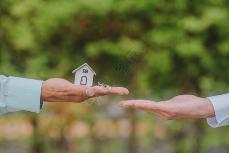 手持钥匙和房屋商业卖主融资租赁住宅卖方投资背景图片