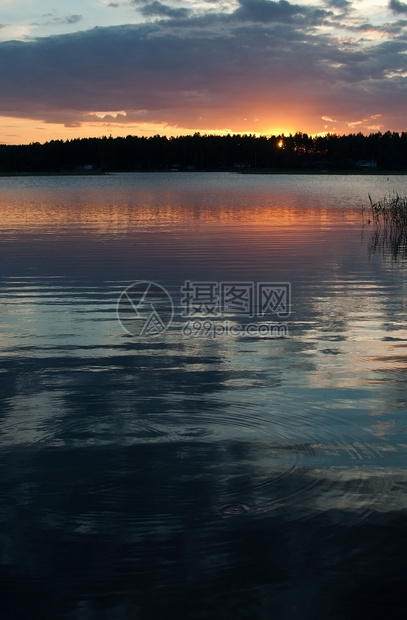 假期在瑞典瓦尔姆兰一个湖与天空反射为宁静水的天空反射在平静水中的和多彩日落在一个湖与天空反光的之间和平多彩日落沉思的经过图片