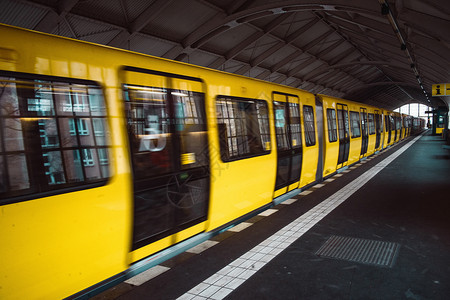 离开柏林市UBahn公共运输地铁内下站的黄色模糊地铁列车到达黄色的图片