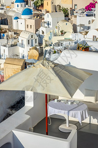 桌子希腊日落之圣托里尼岛卡路德拉的希腊太阳日光天在户外露阳台服务表上的光保护伞下在一个大型太阳伞下夏天火山口图片