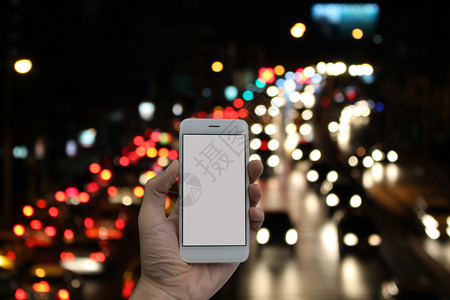 商业男人生活子手握智能电话空白屏幕和夜下交通阻塞模糊的暗器图片
