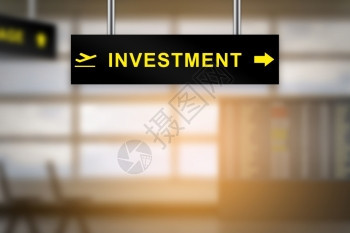 风险公司的投资在机场标志板上背景和复制空间模糊且股票图片