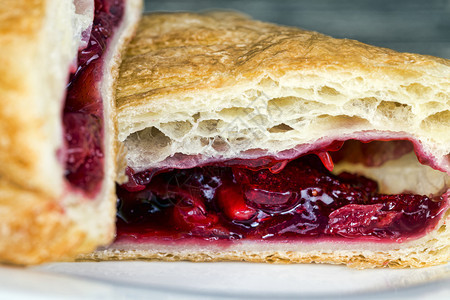 吃对待午餐中间切成面包美味的红樱桃果酱中间切成浆果馅饼包图片
