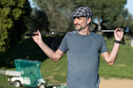 高尔夫球员背着一个高尔夫俱乐部的顶帽高尔夫球员竞赛游戏健康图片
