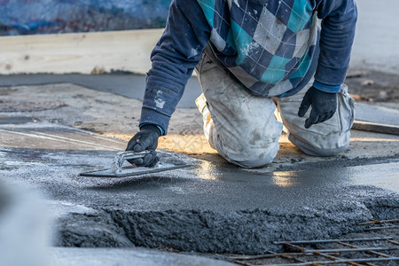 男在建筑工地白天面附近距离靠不明身份工人中路混凝土水泥迫击散落在地下点镘图片