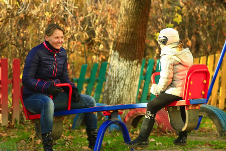 乐趣成人为了母亲和女儿一起去公园的摇摆中兜个风母亲和女儿一起出去兜个风在摇摆中兜个风图片