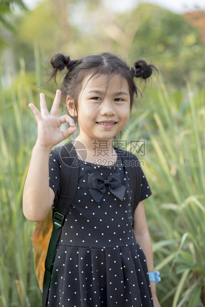 带着学校背包的可爱亚洲儿童手签好用牙齿笑脸的夏天冒险图片