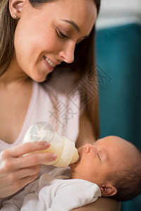 纯度月美丽的爱护母亲近喂养新生儿婴在家喝瓶酒图片