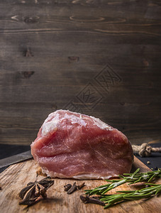 牛肉桌子一块新鲜的生猪肉牛排配有迷迭香丁叶和Dittatny文字场所的剪切板上割图片