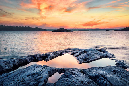 日落时湖面的石头海岸日落时湖面的石头海岸河场景支撑图片