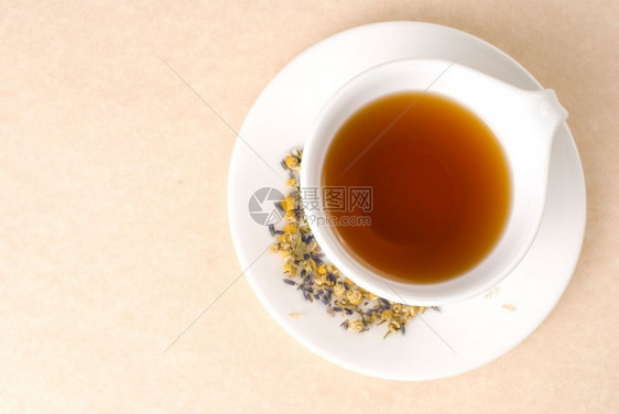 盘子白陶瓷杯中的红茶配花朵装饰早餐茶点图片