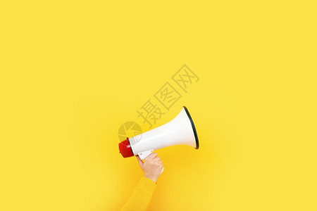 在黄色背景广告概念上手持的扩音器说话颜色宣布图片
