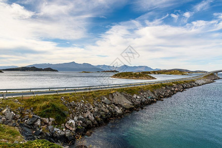 蓝色天空沿海面的阿拉法特公路挪威湾有选择重点美丽岩石云图片