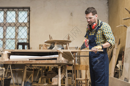 木工专业匠用手锯制板和车间男人工图片