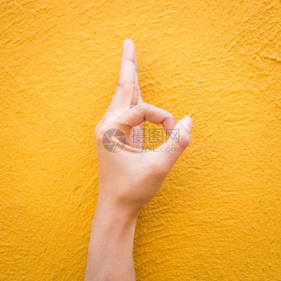 白种人女在水泥黄色墙壁背景上手握好牌协议快乐的图片