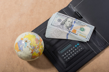 钱金融全球和计算器旁边的美元钞票税图片