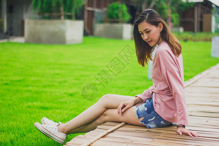 谷物坐着在竹桥上身穿粉红衬衫的女人景观图片