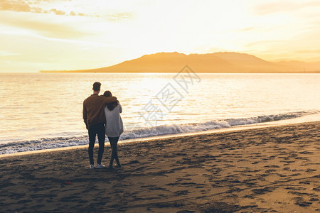 轻松常设妻子拥抱海岸的年轻夫妇图片