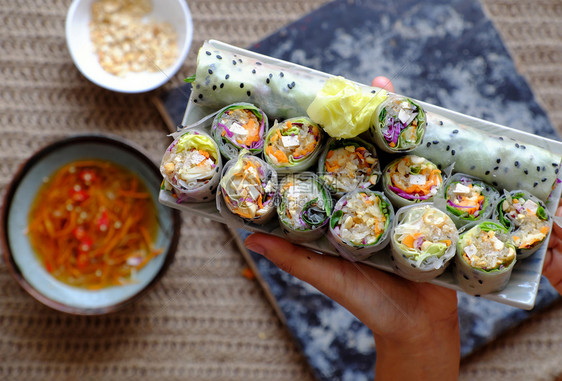 香肠越南春卷素材背景的切片食大米纸卷丰富多彩的蔬菜制作了健康美味的素食菜盘子卷心紫色图片