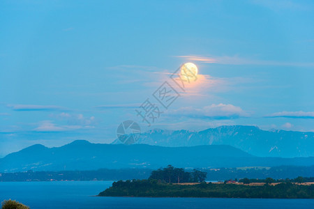 水瓦拉斯智利各十区Llanquihue湖上空云层之间升起的月亮股票图片