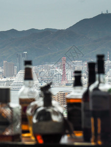 液体JAPANKOBEAPRAIL1207年神户塔和城市天际线在街对神户市天际线上用模糊的威士忌瓶子与模糊的威士忌瓶子对抗神户市图片