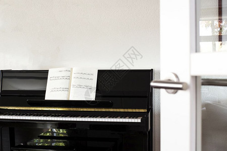 音乐会漆现代白色客厅中的黑钢琴配有乐谱和白色木门现代客厅中的黑钢琴配有乐谱音家图片