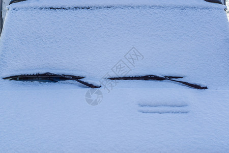 雨刮器一种下雪的车前满是白雪只展示窗户擦拭器寒冷的冬季天气状况降雪设计图片