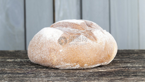 自然传统的躺在木制桌边新鲜面包在木制背景上塞新鲜的黑麦面粉包麸质图片