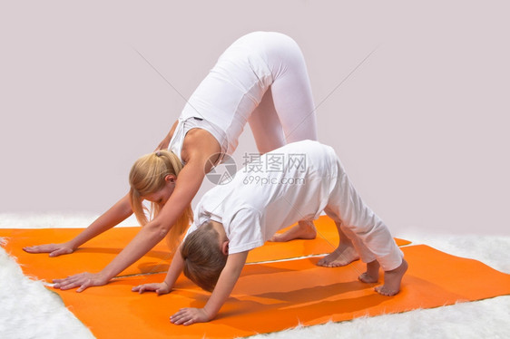 年轻的一个美丽年轻母亲和儿子一起做瑜伽锻炼女孩图片
