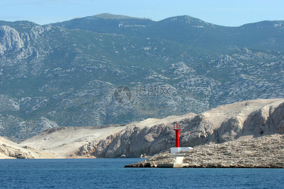 有山地背景的岛上红光照亮蓝色的独自标记图片