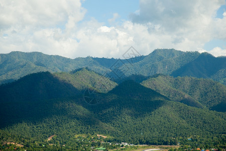 草云层覆盖的天空笼罩着山峰的阴影下岳遍地树木覆盖的山岳风景优美新鲜的图片