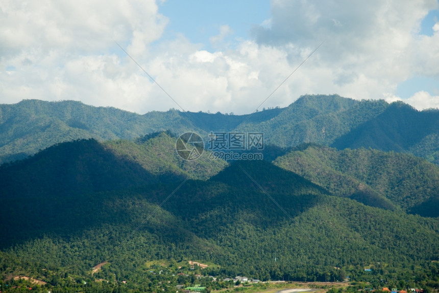 草云层覆盖的天空笼罩着山峰的阴影下岳遍地树木覆盖的山岳风景优美新鲜的图片