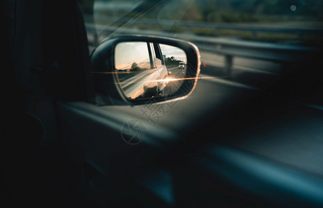 自在汽车侧面镜子和身反照的夜晚阳光在高速公路上快移动的汽车概念侧面镜子视距从后边乘客名单中闪耀着光芒目的地发图片