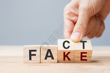 商人手中握着木制立方体翻过街区的FAKEFAKED谣传新闻假消息神话证据和假信息概念积极的互联网帕努瓦图片