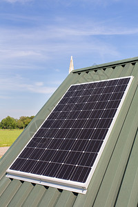 晴天白蓝色空房屋绿顶的太阳能电池板面供应图片