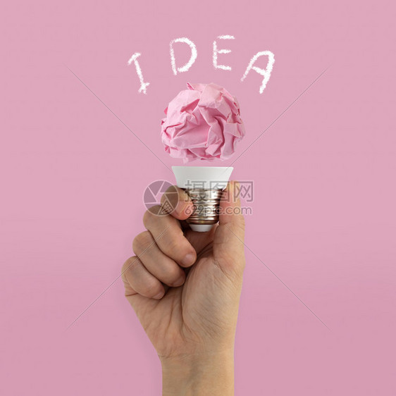 动机纸手持粉红背景思想灵感概念的灯泡照明天才抓住图片