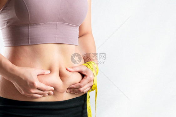 重量胖女人肚子乎的肥女人手握着过多的腹部脂肪用卷尺女人的饮食生活方式概念女孩脂肪团图片