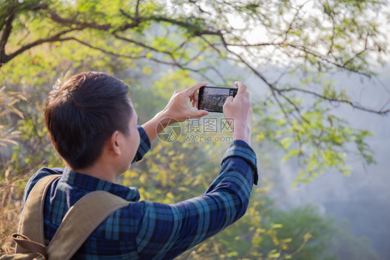 亚洲男旅行者正在使用智能手机拍摄美丽的风景照片校对Portnoy爱摄影师景观图片