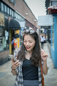 户外短信快乐的年轻时女希望通过智能手机和快乐情绪阅读信息并寻找幸福感图片