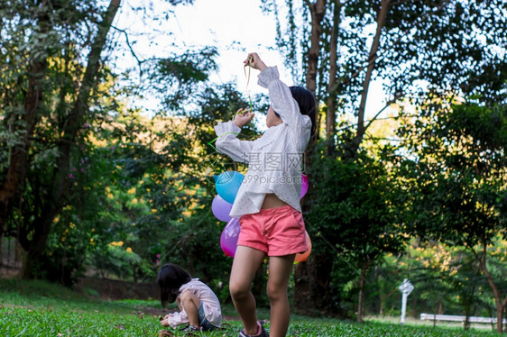 快乐女孩在公园户外露天玩多彩具气球闲暇手亚洲图片