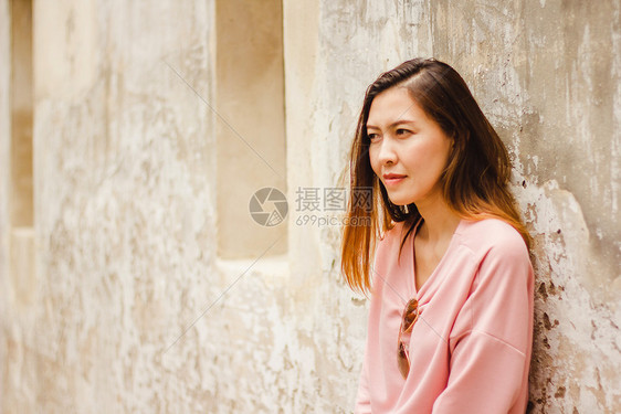 女孩穿粉红衬衫的女士靠着旧墙快乐的吸引人图片