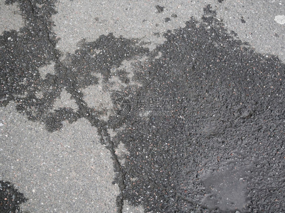 地面黑色的破碎沥青雨后有水坑城市图片