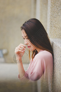 身穿粉红衬衫靠在建筑物墙上的女人漂亮微笑淑女图片