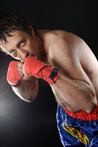 拳手在战斗位置上有伤痕的拳击头黑背景白种人痛拳击手图片