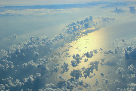 从飞机窗口过云层和海面的美丽景色自然全与云彩白在海面上移动风景与太阳在海面反射从飞机窗口过云层和海面的美丽景色天上射线白图片