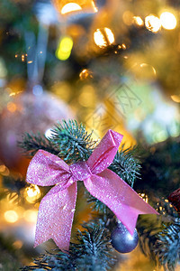 圣诞背景装饰树的绿色枝上带有美丽的粉色蝴蝶结和散景灯背复制空间假日文本的圣诞节概念空间圣诞节概念问候季明亮的图片