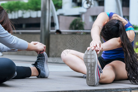 拉伸现代城市的穿运动服在青年女子户外健身锻炼场穿着健康运动服在生活方式女概念外阳光明媚的露天锻炼时女青年子穿着健康运动服闲暇竞技图片