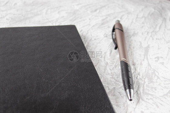 书空白的记事本黑笔和白桌布局背景上的笔顶端视图您的文本有一个位置用于模拟的黑笔记本和在白桌背景上图片