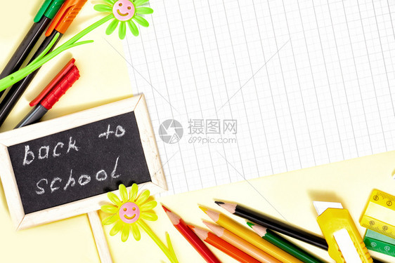 回到学校概念色彩多的轻便笔和板子纸页黄色和绿黛西以及黄色背景的小黑板大学静止的配件图片