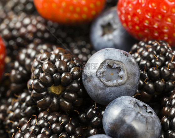覆盆子红莓与蓝和黑的浆果一起躺在桌上夏季时间熟和美味的浆果合照并关闭红莓水果素食主义者图片